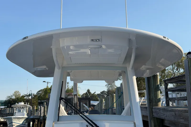 Slide: The Image of 2026 Regulator 28 boat with T-top, docked under clear blue sky. - 59