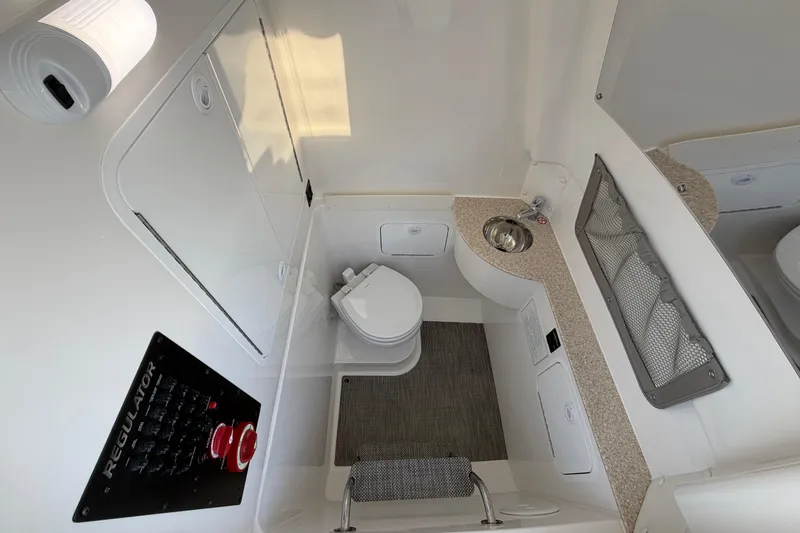 Slide: The Image of 2026 Regulator 28 boat interior with toilet, sink, and control panel. - 64