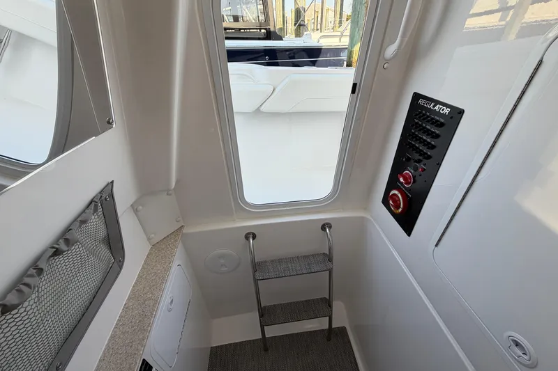 Slide: The Image of Interior view of 2026 Regulator 28 boat, featuring control panel and ladder. - 66