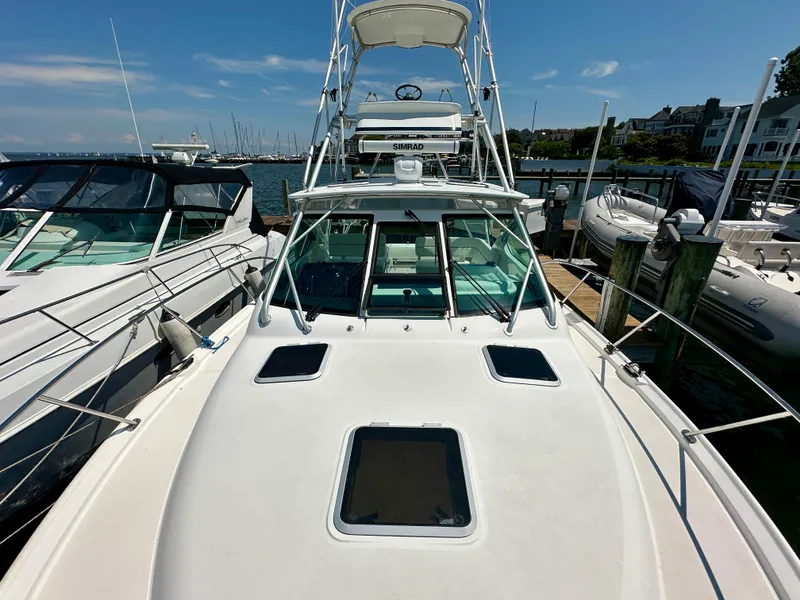 Slide: The Image of 2004 Tiara Yachts 3200 Open docked, showcasing sleek design and spacious deck. - 10