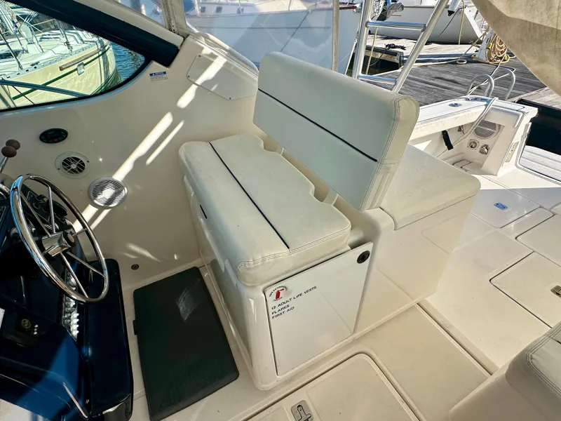 Slide: The Image of 2004 Tiara Yachts 3200 Open cockpit with white seating and steering wheel. - 12