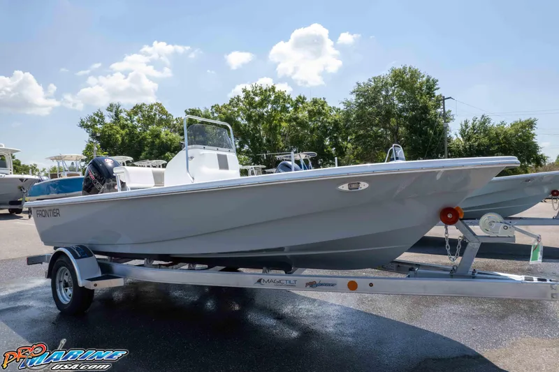 The Image of 2026 Frontier 180 boat on trailer, parked outdoors under a sunny sky. - 1