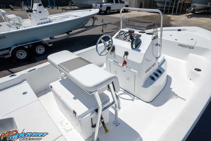 Slide: The Image of 2026 Frontier 180 boat interior with steering console and seating, displayed outdoors. - 21