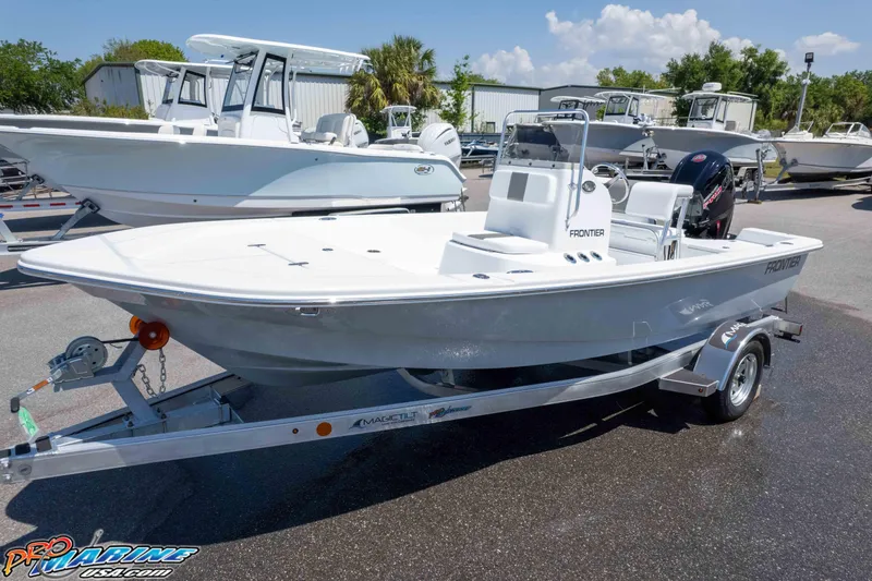 Slide: The Image of 2026 Frontier 180 boat on trailer in outdoor showroom, surrounded by other boats. - 8