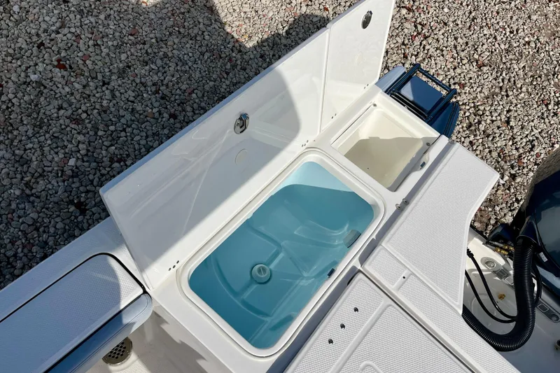 Slide: The Image of 2026 Robalo 226 Cayman boat livewell and storage compartments on deck. - 11