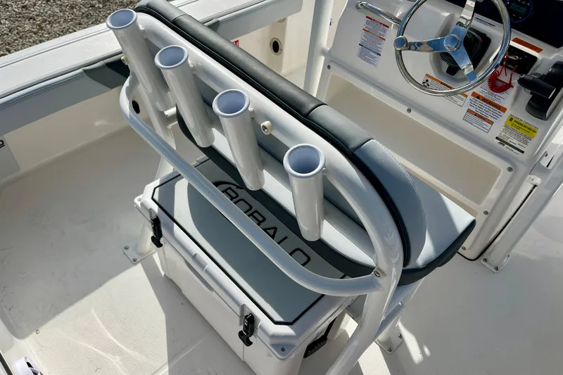 Slide: The Image of 2026 Robalo 226 Cayman boat interior with rod holders and steering wheel. - 13
