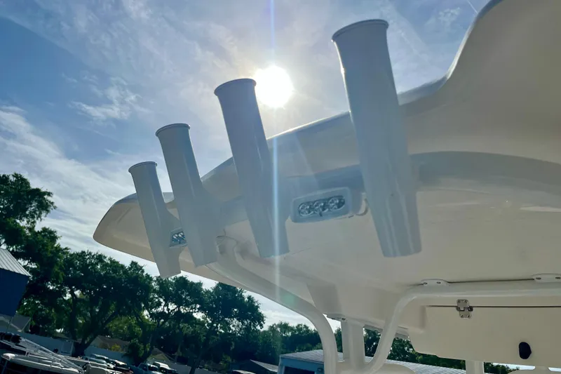 Slide: The Image of 2026 Robalo 226 Cayman boat with rod holders under sunny sky. - 14