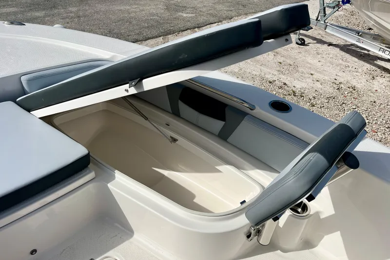 Slide: The Image of Open storage compartment on 2026 Robalo 226 Cayman boat, featuring cushioned seating. - 23