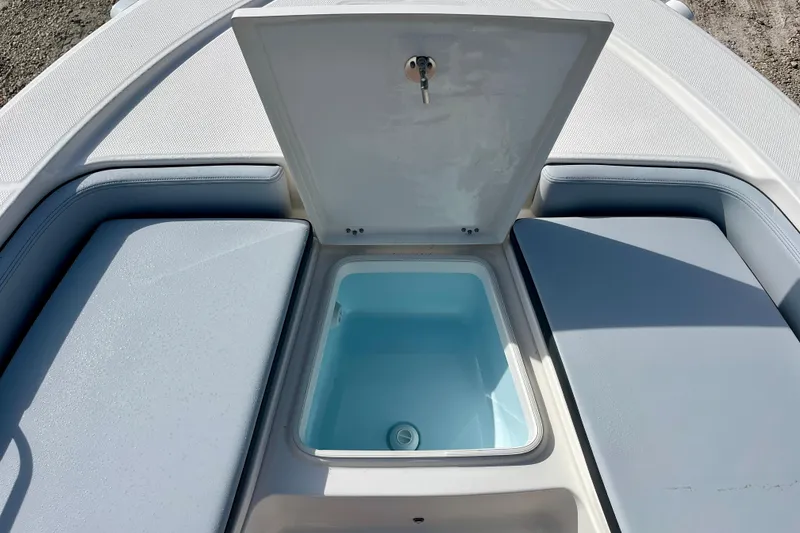 Slide: The Image of Open storage compartment on 2026 Robalo 226 Cayman boat, featuring cushioned seating. - 24
