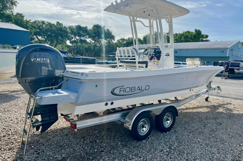 Slide: The Image of 2026 Robalo 226 Cayman boat on trailer with Yamaha engine, parked outdoors. - 6