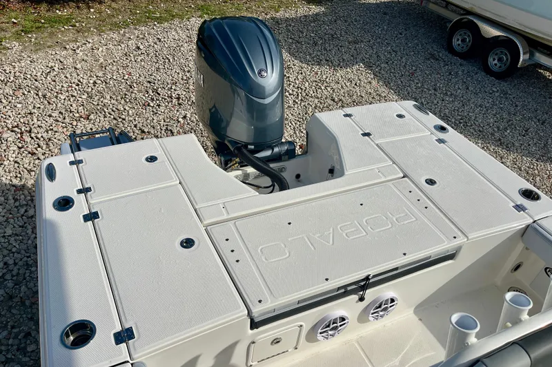 Slide: The Image of 2026 Robalo 226 Cayman boat with outboard motor, viewed from above on gravel surface. - 9