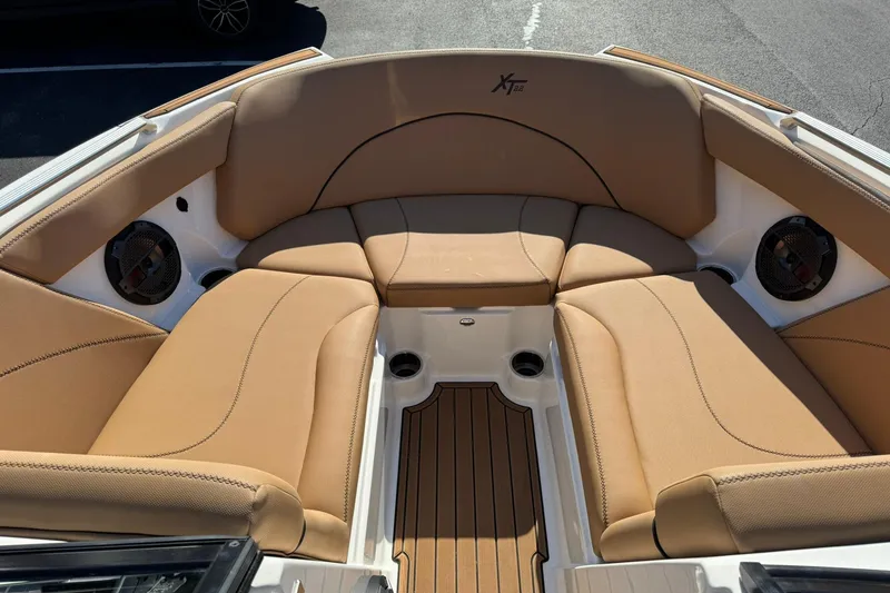 Slide: The Image of 2018 MasterCraft XT22 boat interior with tan seating and wood accents. - 10