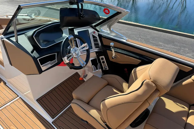 Slide: The Image of 2018 MasterCraft XT22 boat interior with tan seats and modern dashboard design. - 12