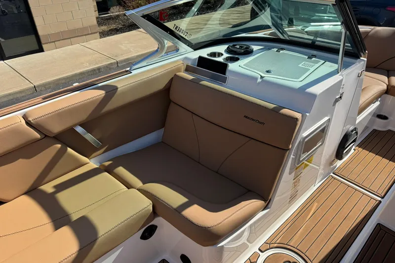 Slide: The Image of 2018 MasterCraft XT22 boat interior with tan seating and wood accents. - 13