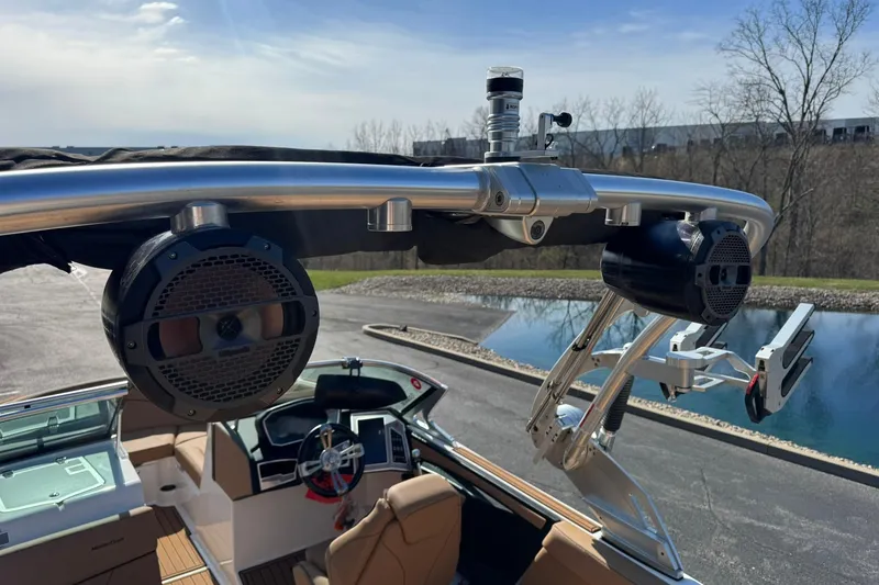 Slide: The Image of 2018 MasterCraft XT22 boat with speakers and wakeboard tower, parked near a pond. - 15