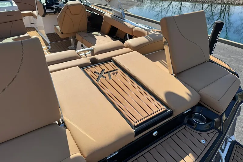 Slide: The Image of 2018 MasterCraft XT22 boat interior with tan seating and wood accents. - 17