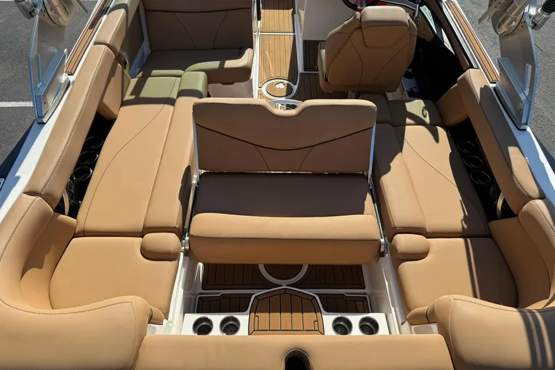 Slide: The Image of 2018 MasterCraft XT22 boat interior with tan leather seating and wood accents. - 19