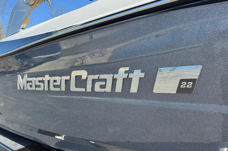 Slide: The Image of 2018 MasterCraft XT22 boat logo on sleek, metallic surface. - 2