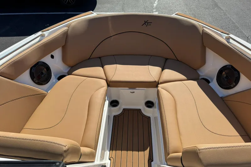 Slide: The Image of 2018 MasterCraft XT22 boat interior with tan seating and wood accents. - 20