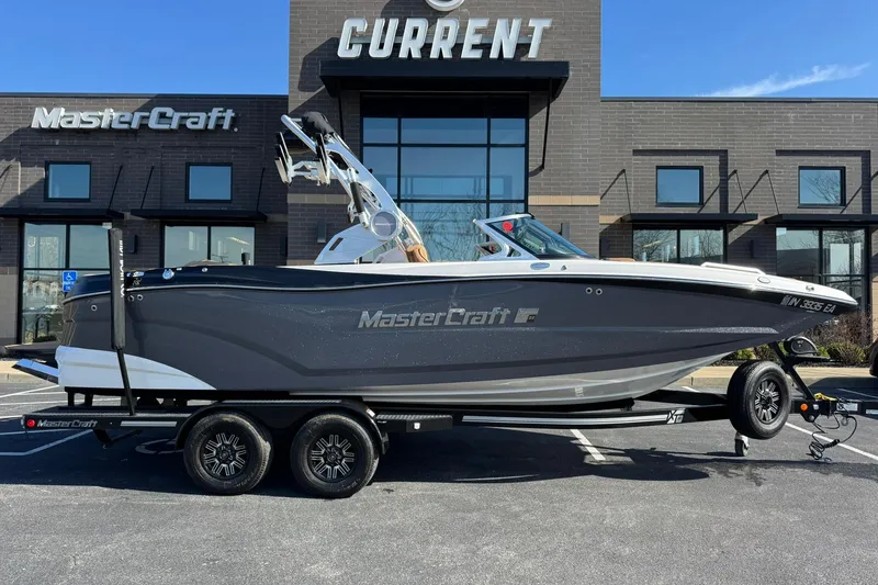 Slide: The Image of 2018 MasterCraft XT22 boat on trailer in front of dealership. - 23