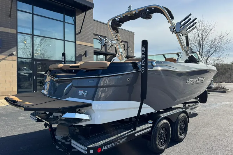 Slide: The Image of 2018 MasterCraft XT22 boat on trailer outside a modern building. - 3