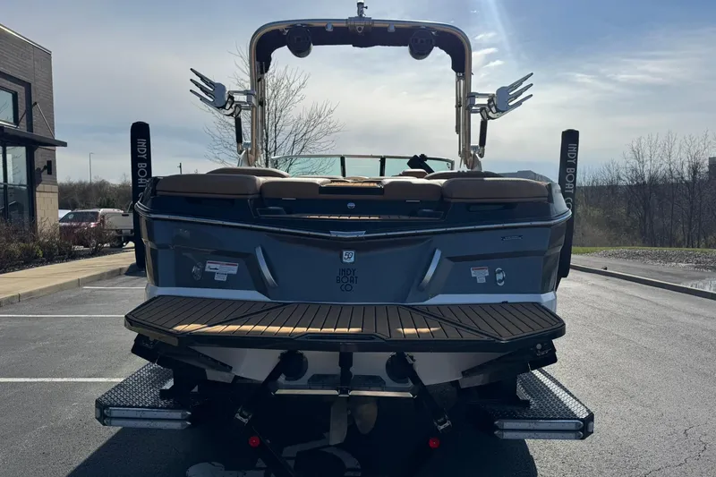 Slide: The Image of 2018 MasterCraft XT22 boat rear view in parking lot, showcasing sleek design and features. - 4