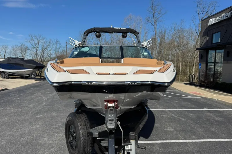 Slide: The Image of 2018 MasterCraft XT22 boat on trailer in parking lot, clear sky background. - 7
