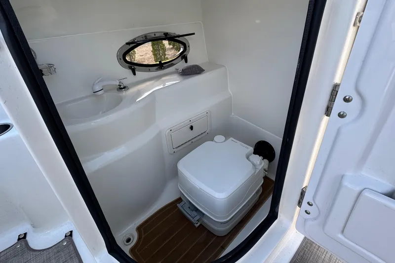 Slide: The Image of Interior of 2017 NauticStar 243DC Sport Deck boat with compact marine toilet. - 18
