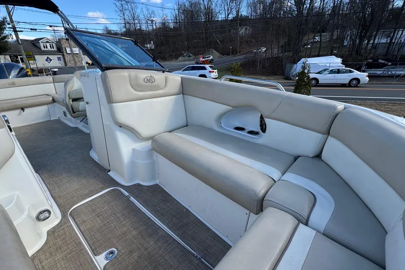 Slide: The Image of 2017 NauticStar 243DC Sport Deck boat interior with beige seating and open deck layout. - 20