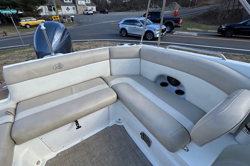 Slide: The Image of 2017 NauticStar 243DC Sport Deck boat interior with beige seating and cup holders. - 4