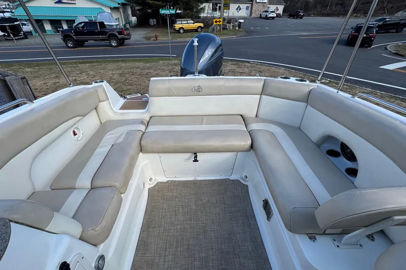 Slide: The Image of 2017 NauticStar 243DC Sport Deck boat interior with beige seating and cup holders. - 6