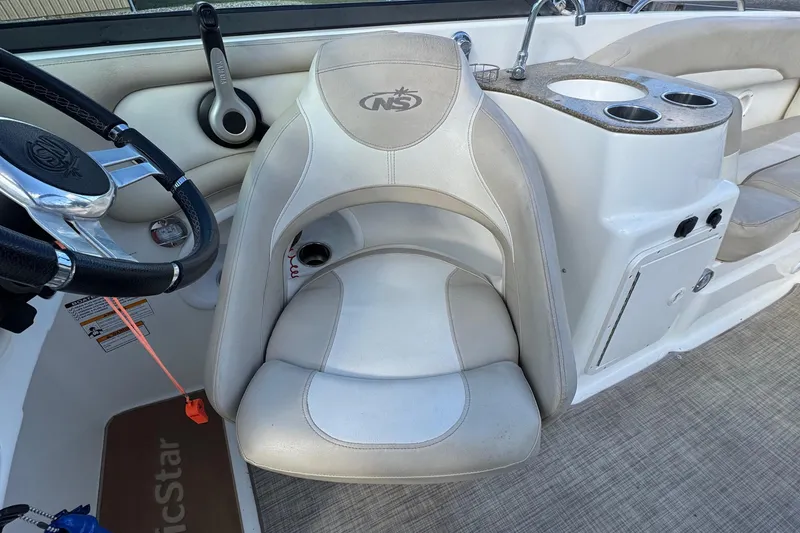 Slide: The Image of 2017 NauticStar 243DC Sport Deck boat interior with steering wheel and seating area. - 8