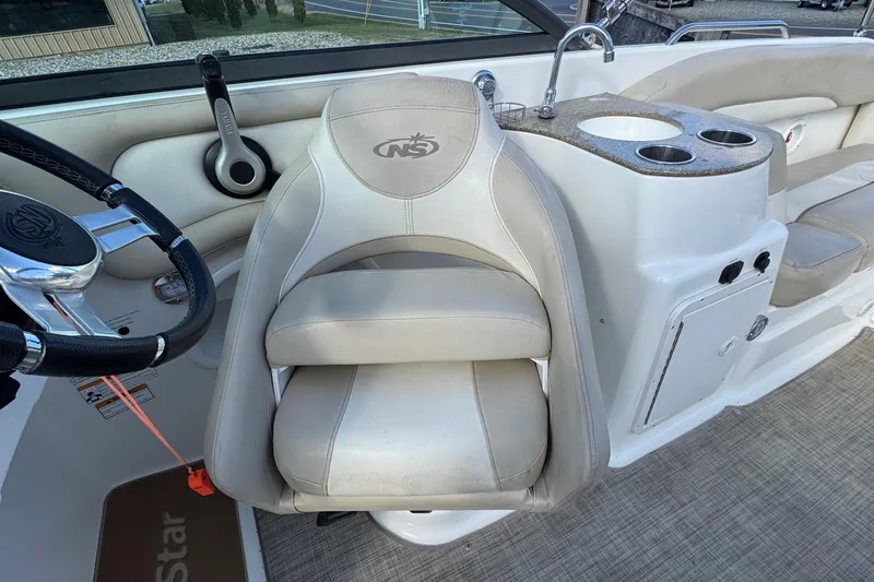 Slide: The Image of 2017 NauticStar 243DC Sport Deck interior with steering wheel, seat, and cup holders. - 9