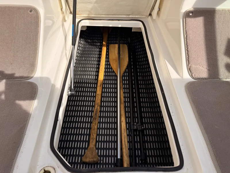Slide: The Image of 2003 Regal 2000 Bowrider storage compartment with paddles. - 19