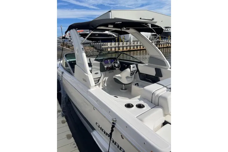 Slide: The Image of 2023 Chaparral 270 OSX boat docked, featuring sleek interior and modern controls. - 2