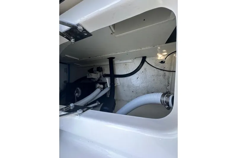Slide: The Image of 2023 Chaparral 270 OSX boat interior compartment with visible hoses and fittings. - 21