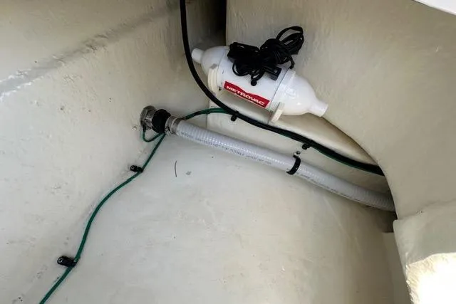 Slide: The Image of 2023 Chaparral 270 OSX boat interior showing a bilge pump and hose setup. - 26