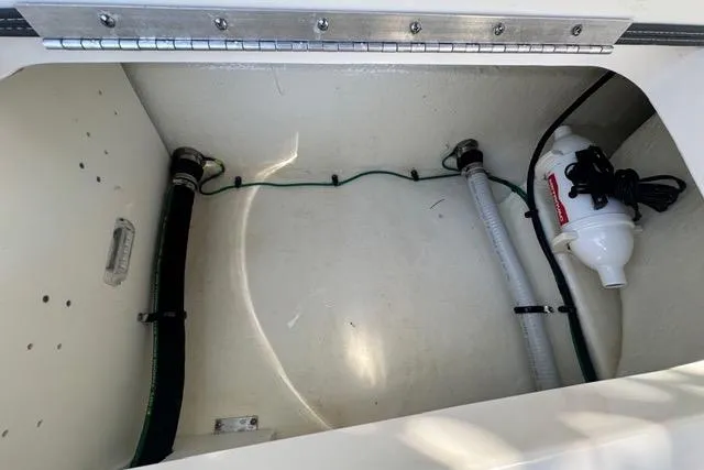 Slide: The Image of 2023 Chaparral 270 OSX boat storage compartment with hoses and equipment. - 29