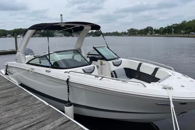 Slide: The Image of 2023 Chaparral 270 OSX boat docked by a serene lake. - 3