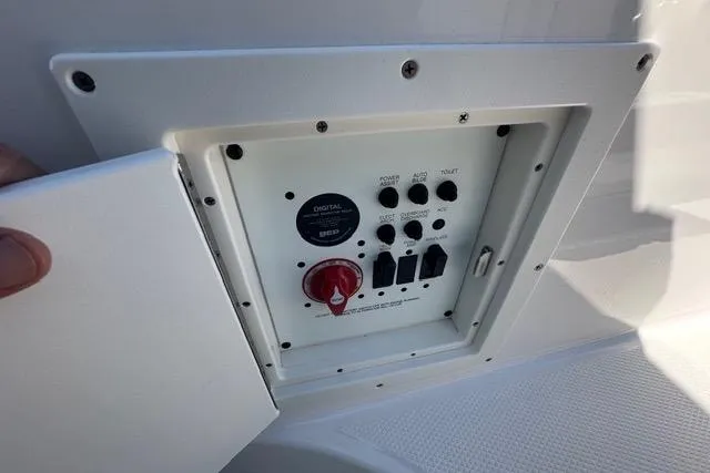 Slide: The Image of Control panel of 2023 Chaparral 270 OSX boat, featuring switches and a red dial. - 30