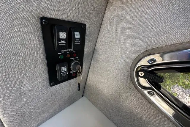 Slide: The Image of Control panel inside 2023 Chaparral 270 OSX boat, featuring switches and key ignition. - 35