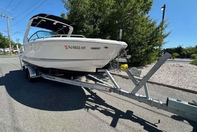 Slide: The Image of 2023 Chaparral 270 OSX boat on trailer, parked on a sunny street. - 8