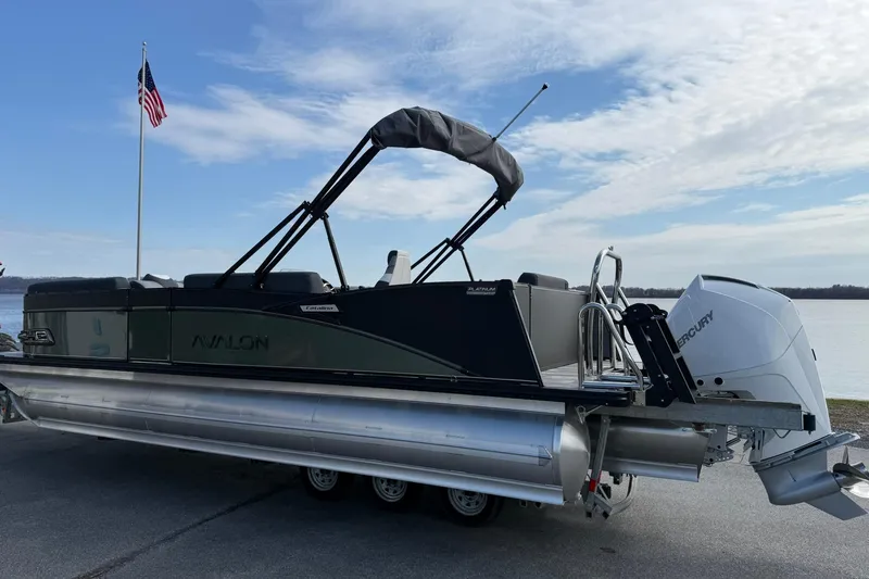 Slide: The Image of 2026 Avalon Catalina Elite 23 pontoon boat with Mercury engine by a lakeside. - 3