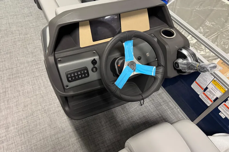 Slide: The Image of 2026 Sun Tracker SportFish 20 DLX boat dashboard with steering wheel and controls. - 10