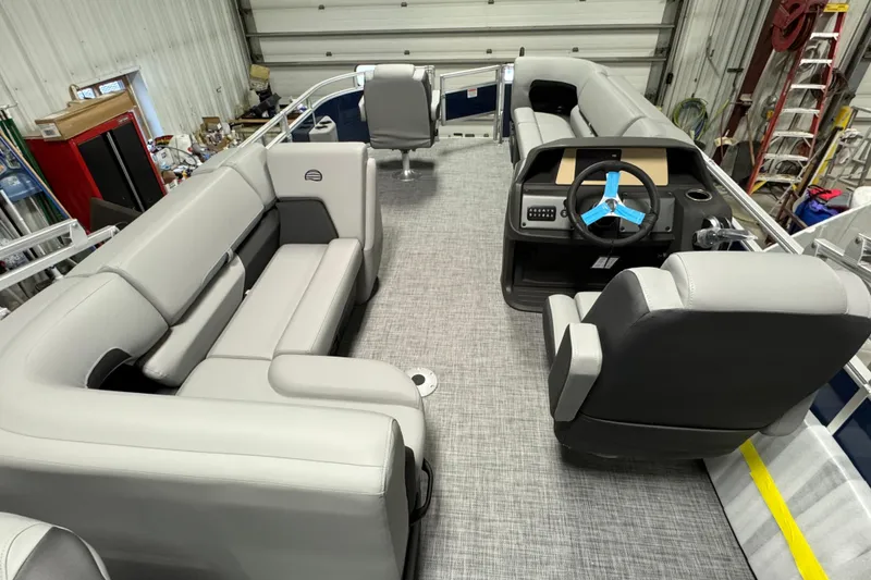 Slide: The Image of 2026 Sun Tracker SportFish 20 DLX pontoon boat interior with gray seating and steering console. - 11