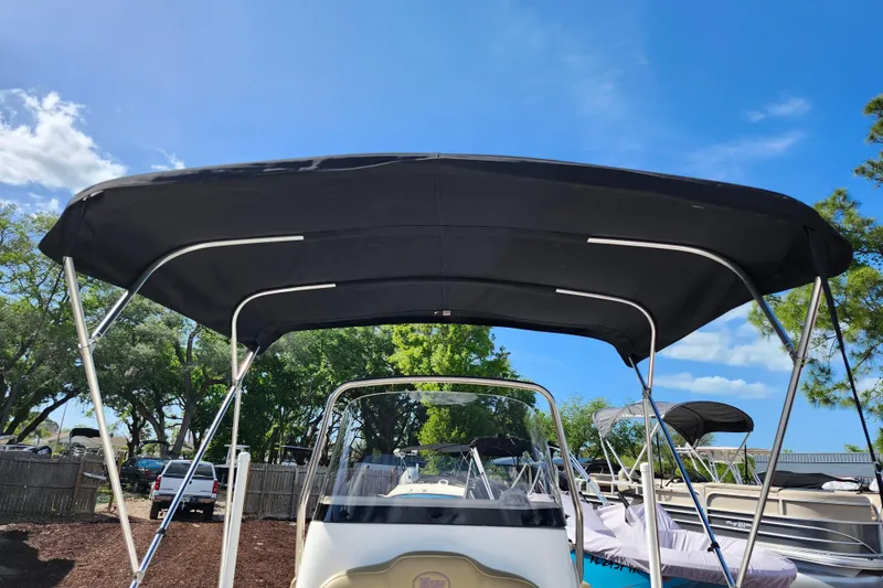 Slide: The Image of 2019 Key West 189 FS boat with black bimini top under clear blue sky. - 11