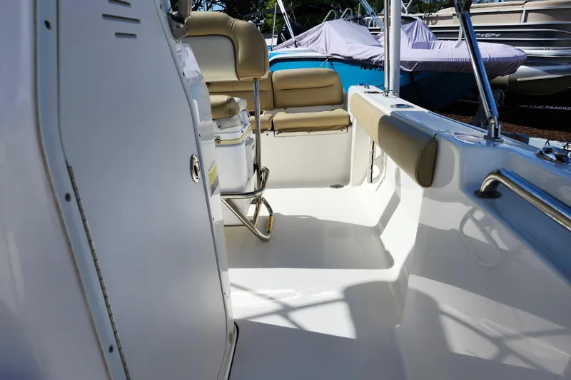 Slide: The Image of 2019 Key West 189 FS boat interior with beige seating and sleek white surfaces. - 14