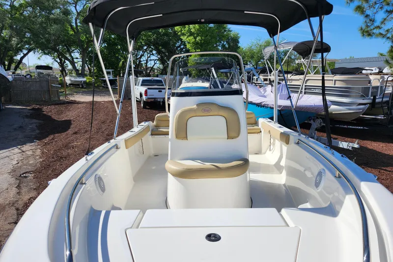 Slide: The Image of 2019 Key West 189 FS boat with seating, canopy, and sleek design in a marina setting. - 18