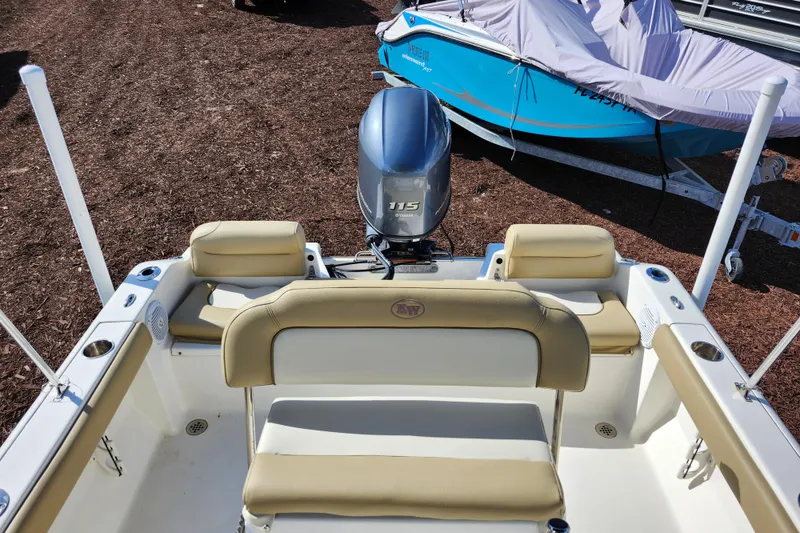 Slide: The Image of 2019 Key West 189 FS boat with Yamaha 115 engine, beige seating, and covered boat nearby. - 29