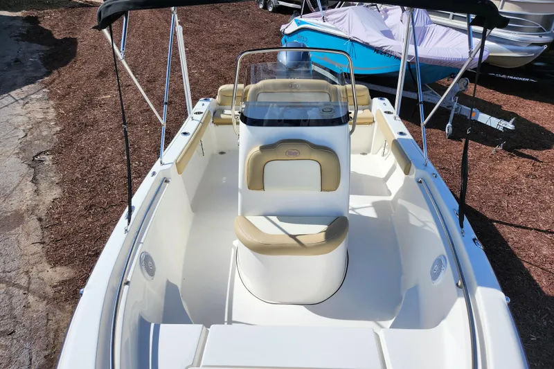 Slide: The Image of 2019 Key West 189 FS boat with beige seating and canopy, parked on mulch. - 9